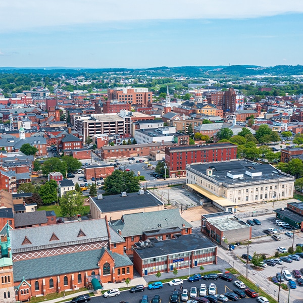 Aerial view of a vibrant cityscape with mixed historic and modern architecture under a clear blue sky.